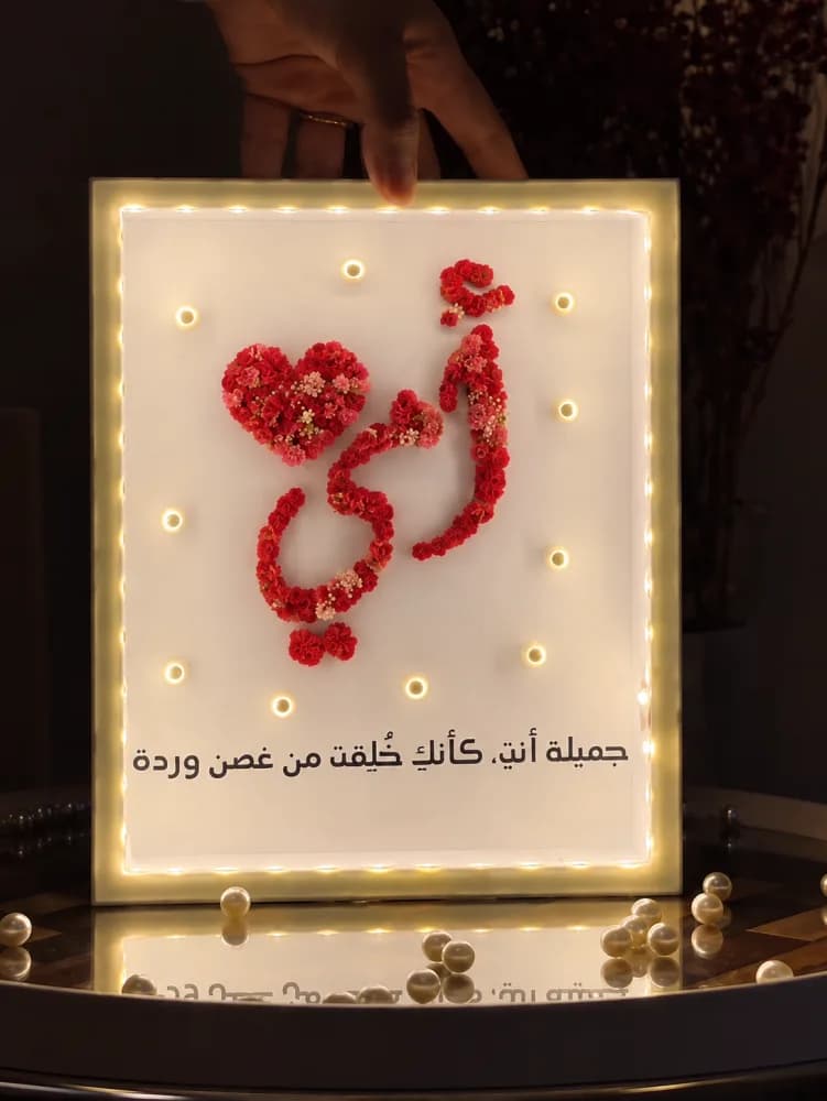 صورة لوحة مضيئة بالاسم مع زهور