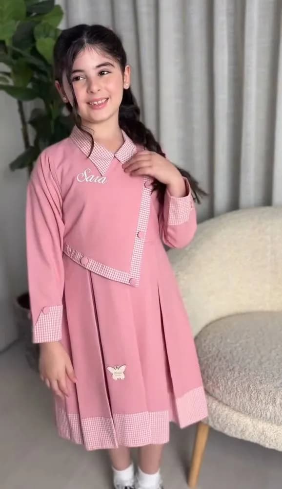 صورة مريول مدرسي بناتي وردي بياقة وأطراف منقوشة